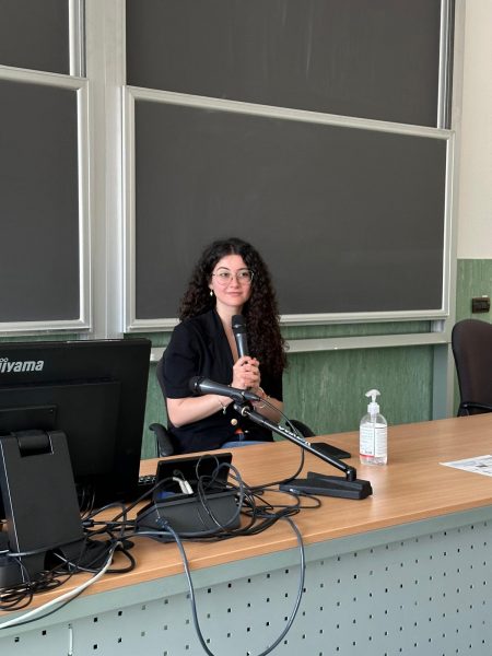 L'immagine mostra la studentessa impegnata in un intervento in lingua inglese in occasione di una conferenza presso l'Università degli Studi di Milano